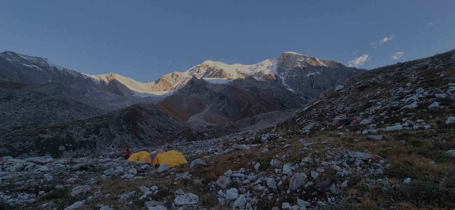Yellow expedition tents beneath snow-covered Himalayan peaks